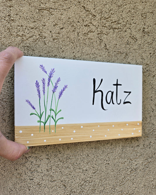 שלט לדלת כניסה עם ציור של פרח לבנדר בעבודת יד על רקע לבן עם פס עץ טבעי