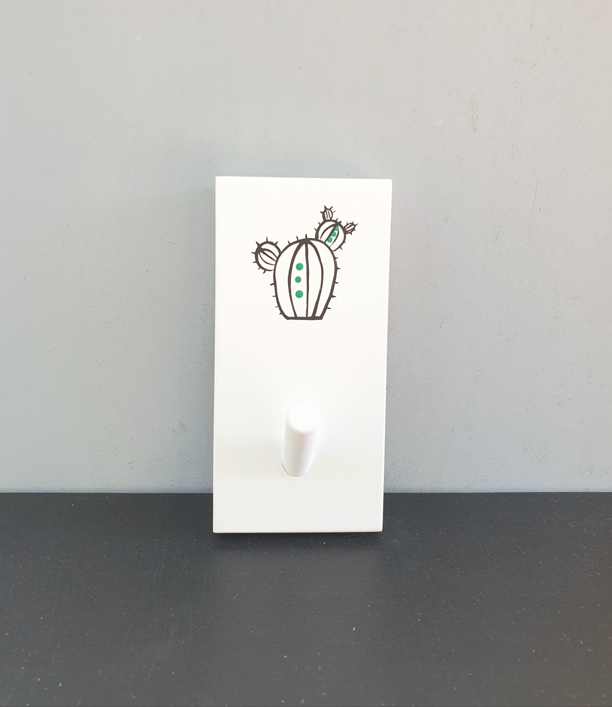 מתלה עץ עם וו תלייה מצויר בעבודת יד קקטוס שחור עם נקודות ירוקות על רקע לבן מתלה לבגדים תיקים ומגבות לכניסה לבית חדר רחצה וחדר ילדים עיצוב נקי מודרני