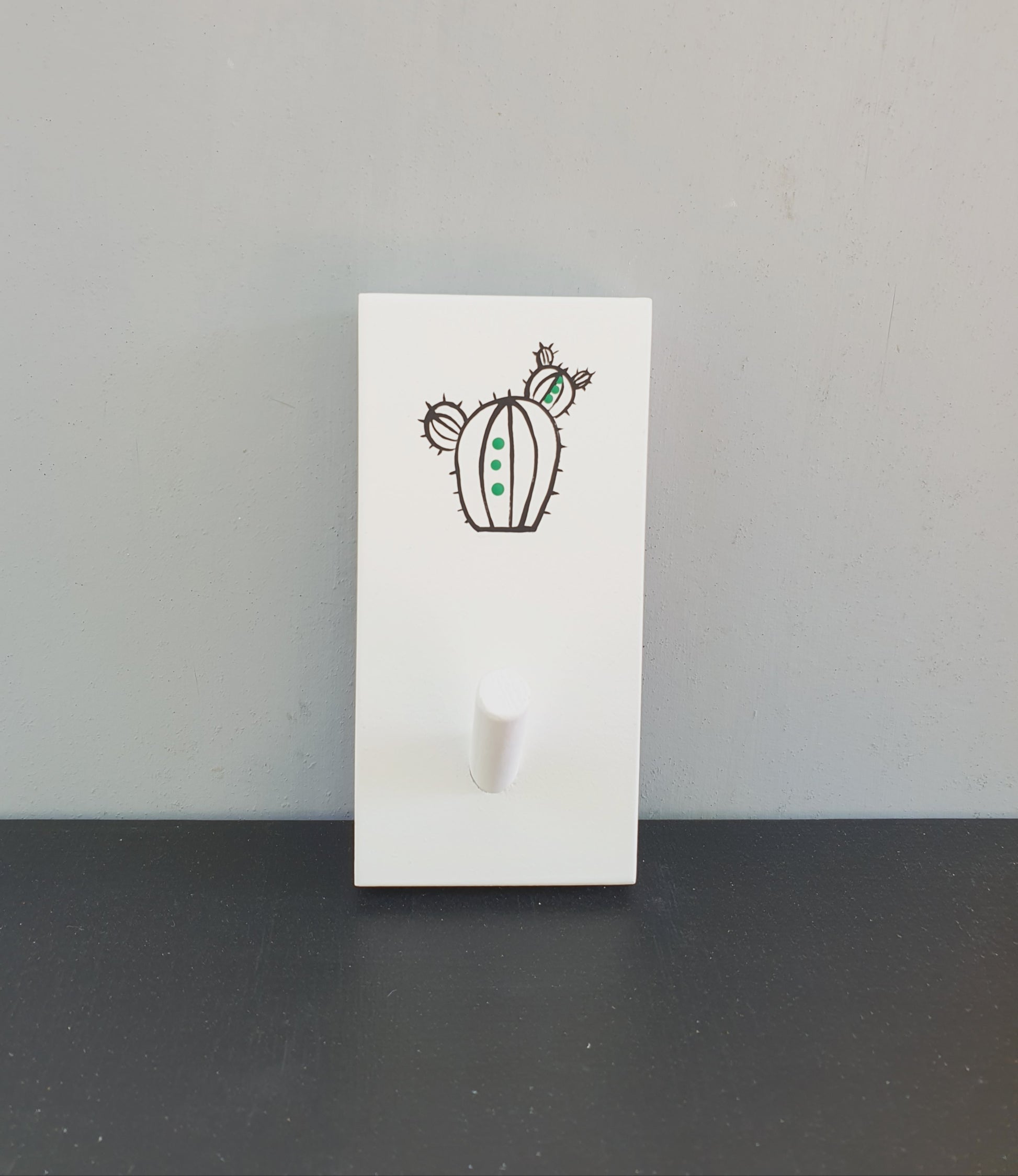 מתלה עץ עם וו תלייה מצויר בעבודת יד קקטוס שחור עם נקודות ירוקות על רקע לבן מתלה לבגדים תיקים ומגבות לכניסה לבית חדר רחצה וחדר ילדים עיצוב נקי מודרני