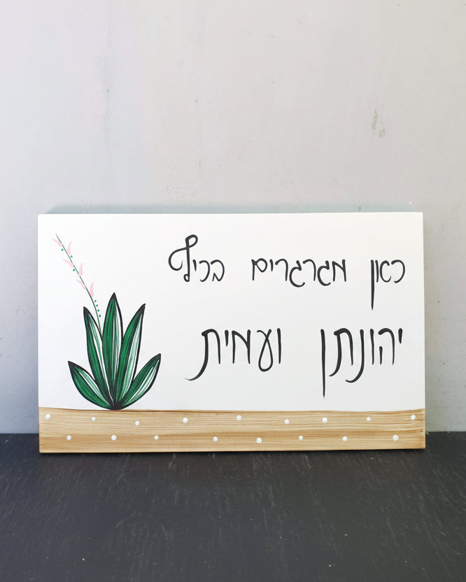 שלט לדלת כניסה עם צמח ירוק וכיתוב אישי בעבודת יד על בסיס עץ טבעי