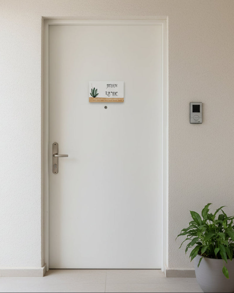 שלט לדלת כניסה עם צמח ירוק וכיתוב אישי בעבודת יד על בסיס עץ טבעי