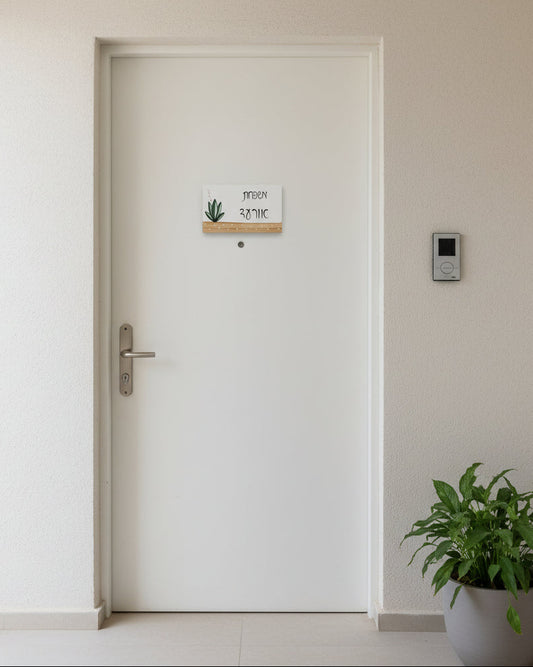 שלט לדלת כניסה עם צמח ירוק וכיתוב אישי בעבודת יד על בסיס עץ טבעי