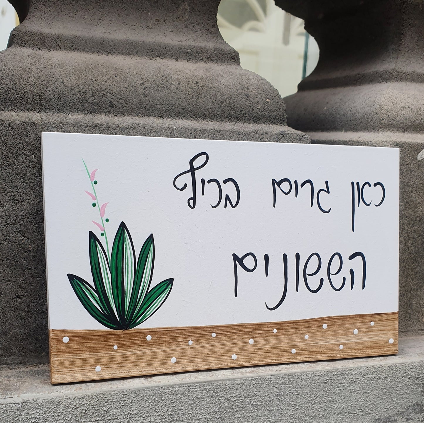 שלט לדלת כניסה עם צמח ירוק וכיתוב אישי