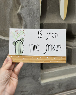 שלט לדלת כניסה עם איור קקטוס וכיתוב אישי בעיצוב מינימליסט
