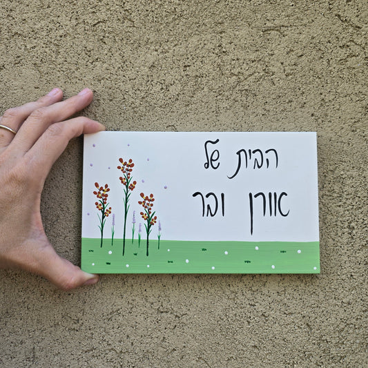 שלט לדלת כניסה עם פרחי בר עדינים וכיתוב אישי, שלט עץ בעבודת יד לבית ולמשפחה, מתנה לחנוכת בית